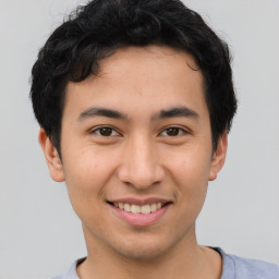 Joyful asian young-adult male with short  brown hair and brown eyes