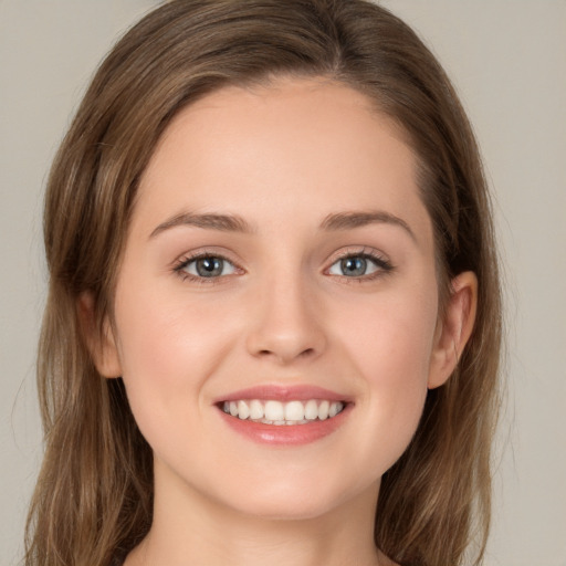 Joyful white young-adult female with long  brown hair and green eyes