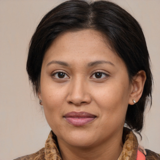 Joyful latino adult female with medium  brown hair and brown eyes