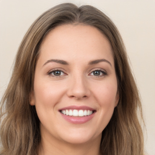 Joyful white young-adult female with long  brown hair and green eyes