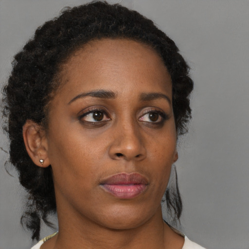 Neutral black young-adult female with medium  brown hair and brown eyes