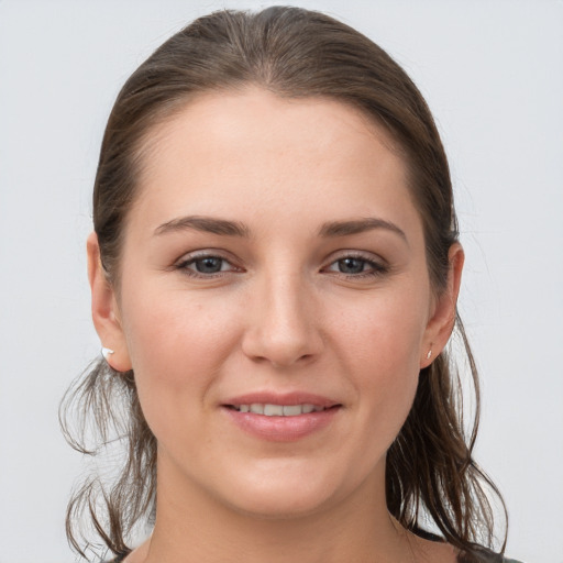 Joyful white young-adult female with medium  brown hair and grey eyes