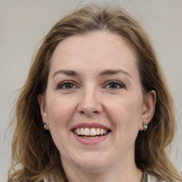 Joyful white adult female with medium  brown hair and grey eyes