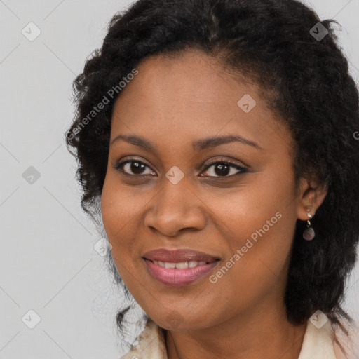 Joyful black adult female with long  brown hair and brown eyes