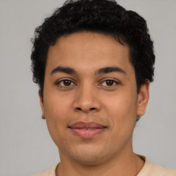 Joyful latino young-adult male with short  brown hair and brown eyes