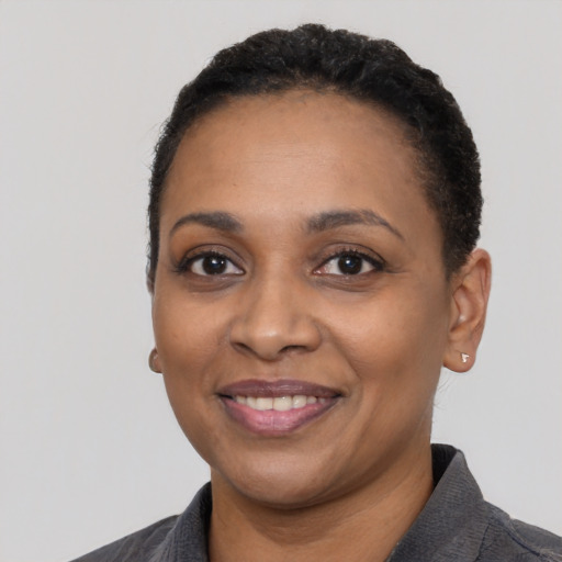 Joyful black adult female with short  black hair and brown eyes