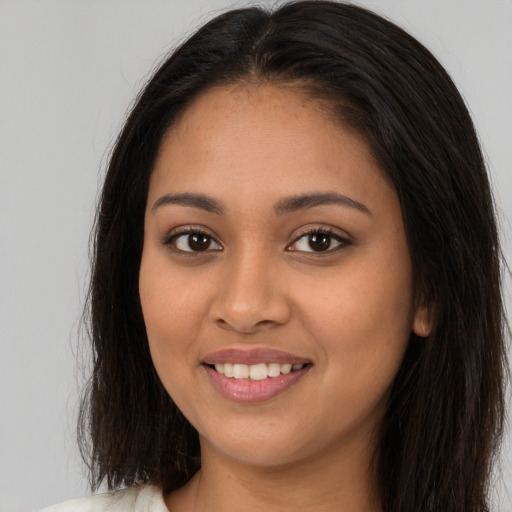 Joyful latino young-adult female with long  brown hair and brown eyes