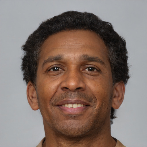 Joyful black adult male with short  brown hair and brown eyes