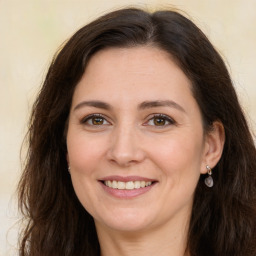 Joyful white adult female with long  brown hair and brown eyes