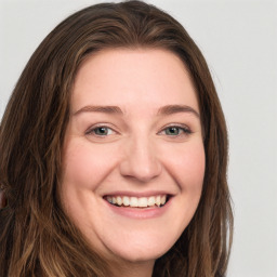 Joyful white young-adult female with long  brown hair and blue eyes