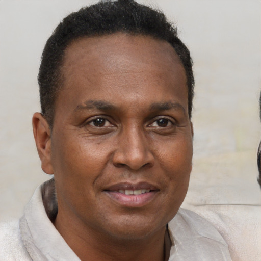 Joyful black adult male with short  brown hair and brown eyes