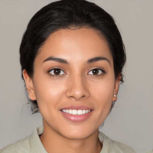 Joyful latino young-adult female with medium  brown hair and brown eyes