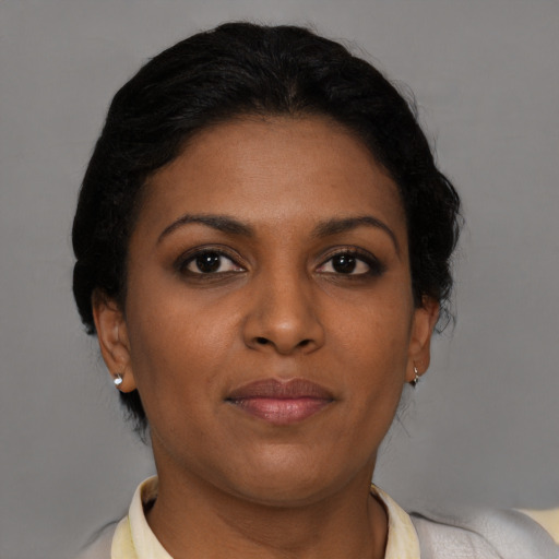 Joyful black young-adult female with short  brown hair and brown eyes