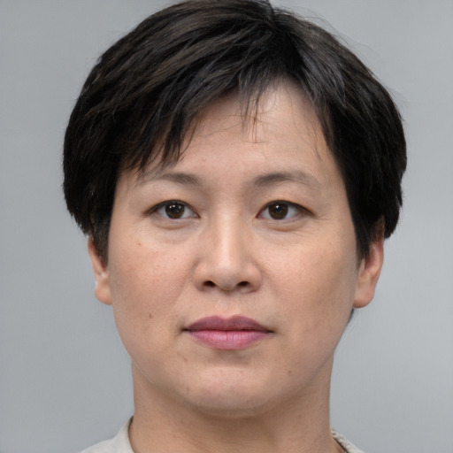Joyful asian adult female with short  brown hair and brown eyes