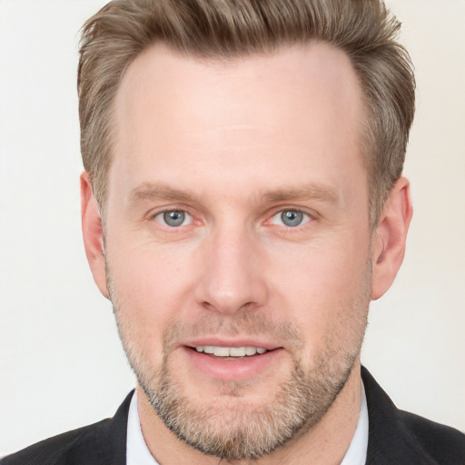 Joyful white adult male with short  brown hair and blue eyes