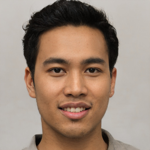 Joyful asian young-adult male with short  black hair and brown eyes
