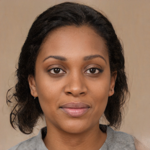 Joyful black young-adult female with medium  brown hair and brown eyes