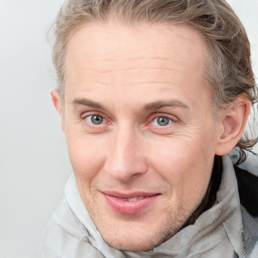 Joyful white adult male with short  brown hair and blue eyes