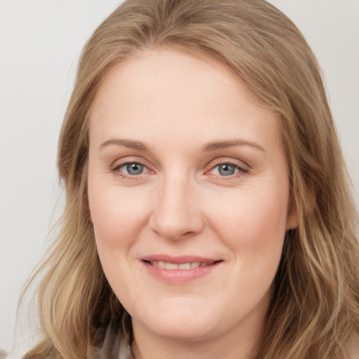 Joyful white young-adult female with long  brown hair and blue eyes