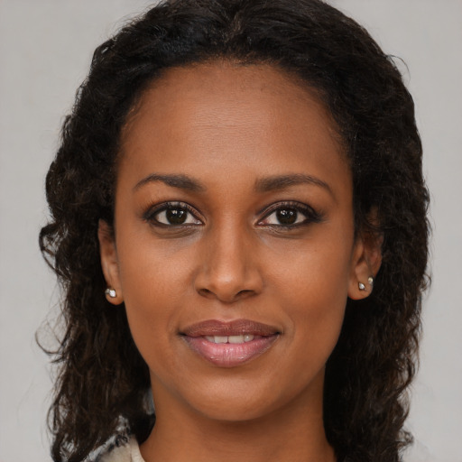 Joyful black young-adult female with medium  brown hair and brown eyes