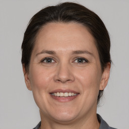 Joyful white adult female with medium  brown hair and grey eyes