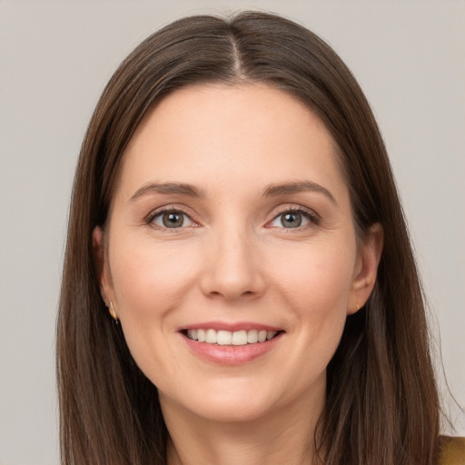 Joyful white young-adult female with long  brown hair and grey eyes