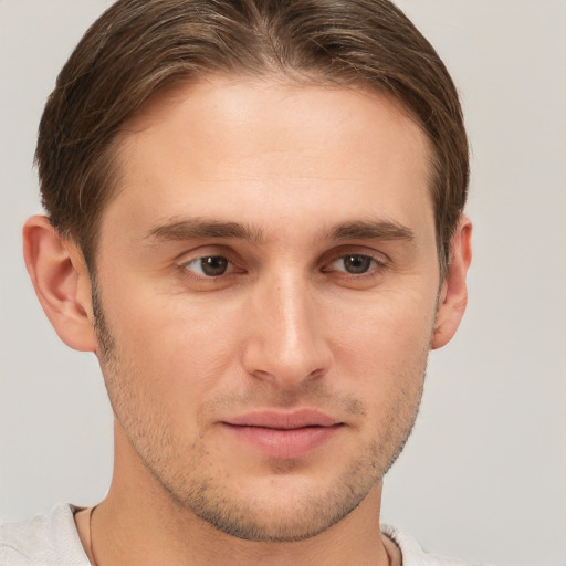 Joyful white young-adult male with short  brown hair and grey eyes