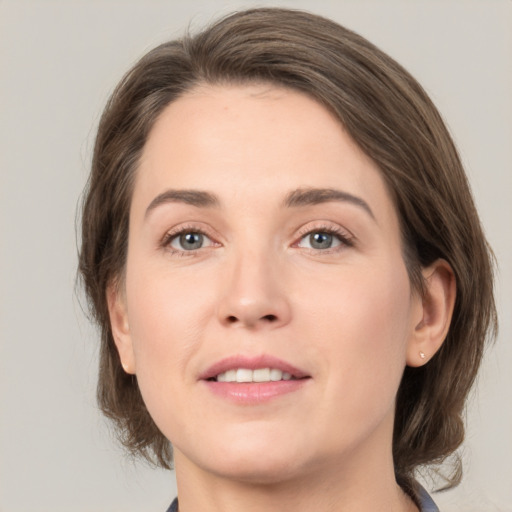 Joyful white young-adult female with medium  brown hair and grey eyes