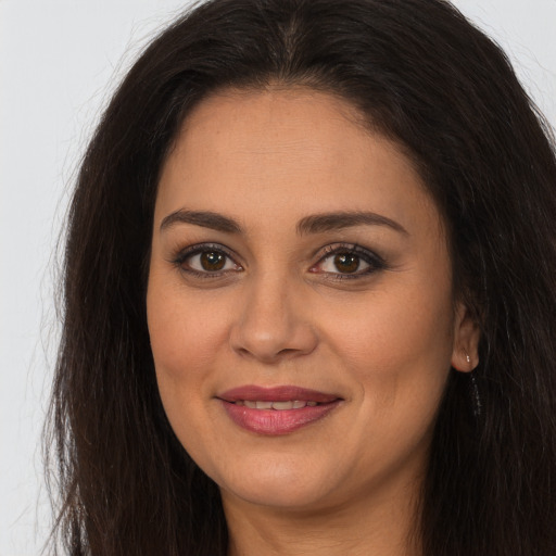 Joyful white young-adult female with long  brown hair and brown eyes