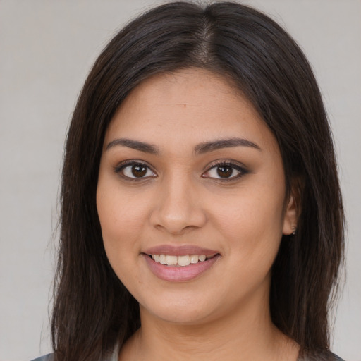 Joyful latino young-adult female with long  brown hair and brown eyes