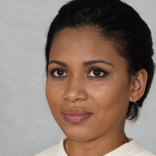 Joyful black young-adult female with short  black hair and brown eyes