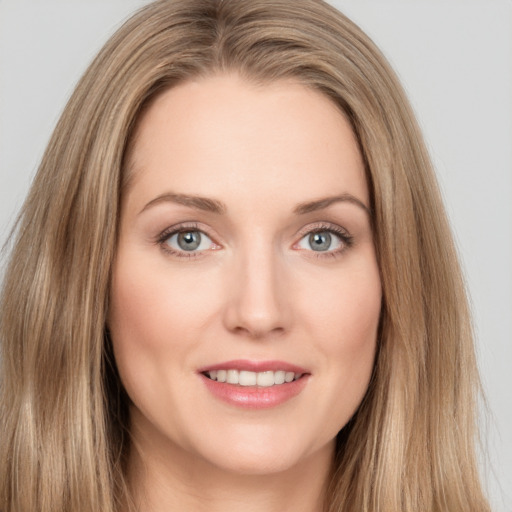 Joyful white young-adult female with long  brown hair and green eyes