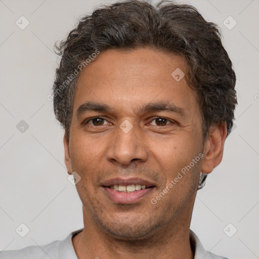 Joyful latino adult male with short  brown hair and brown eyes