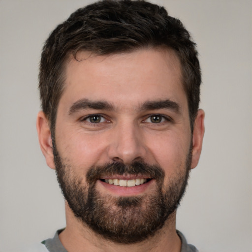 Joyful white young-adult male with short  black hair and brown eyes