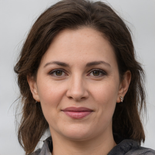 Joyful white young-adult female with medium  brown hair and grey eyes