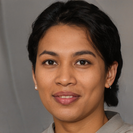 Joyful latino young-adult female with short  black hair and brown eyes