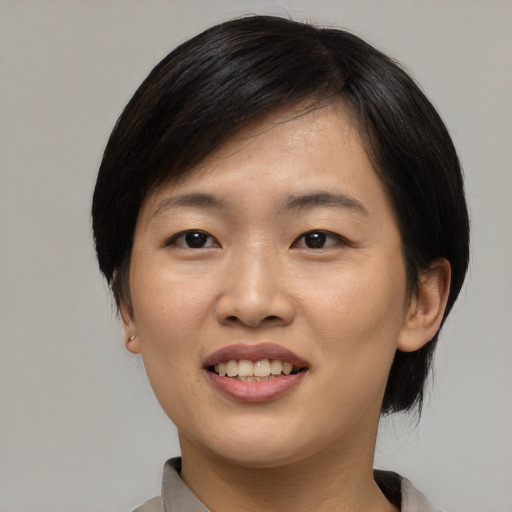 Joyful asian young-adult female with medium  black hair and brown eyes
