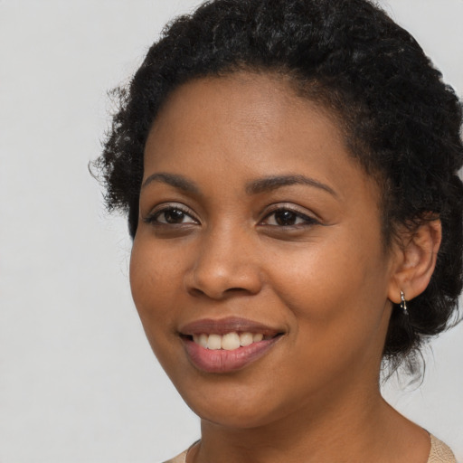 Joyful black young-adult female with long  black hair and brown eyes