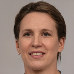 Joyful white adult female with medium  brown hair and grey eyes