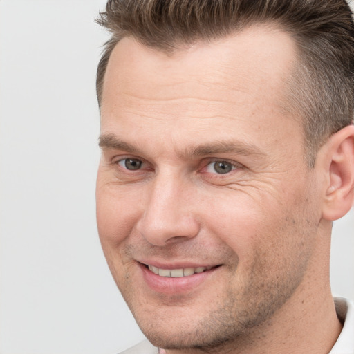 Joyful white adult male with short  brown hair and brown eyes