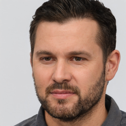 Joyful white adult male with short  brown hair and brown eyes