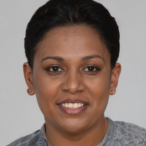 Joyful black young-adult female with short  black hair and brown eyes