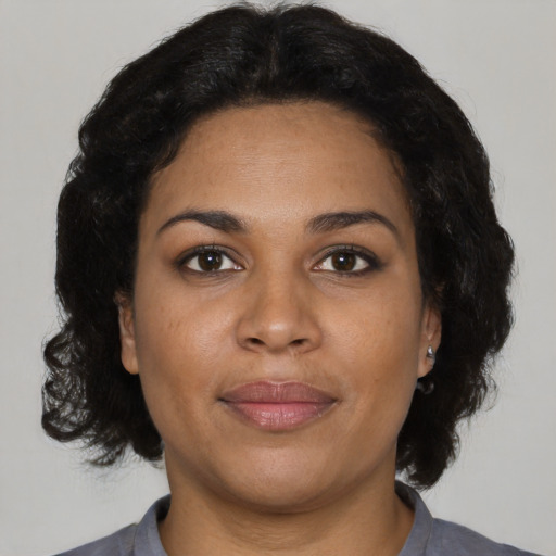 Joyful black adult female with short  brown hair and brown eyes
