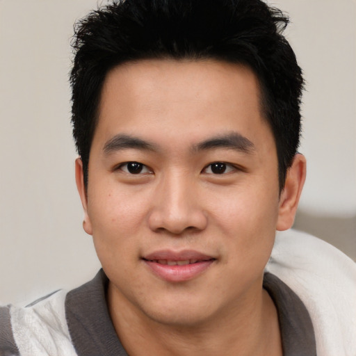 Joyful asian young-adult male with short  black hair and brown eyes
