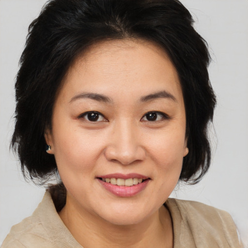Joyful asian adult female with medium  brown hair and brown eyes