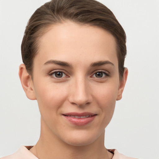 Joyful white young-adult female with short  brown hair and grey eyes