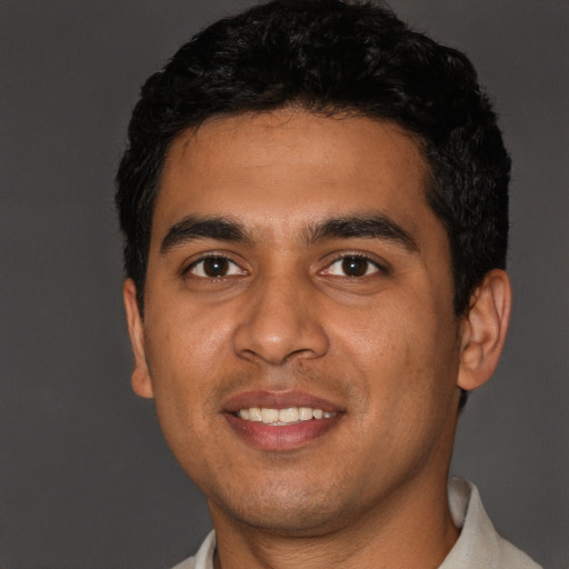 Joyful latino young-adult male with short  black hair and brown eyes