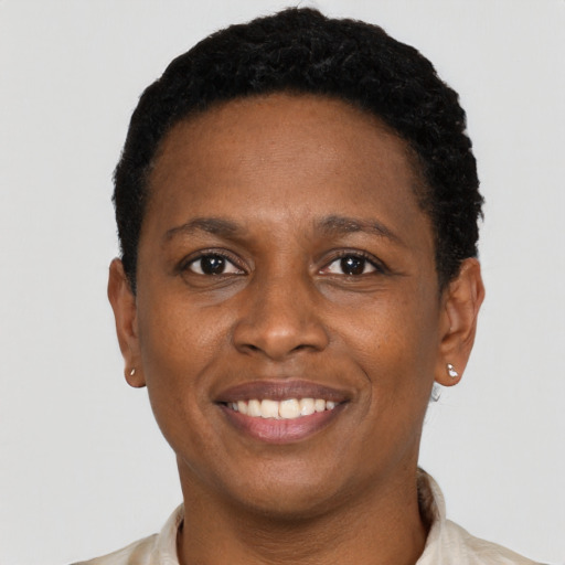 Joyful black young-adult female with short  black hair and brown eyes