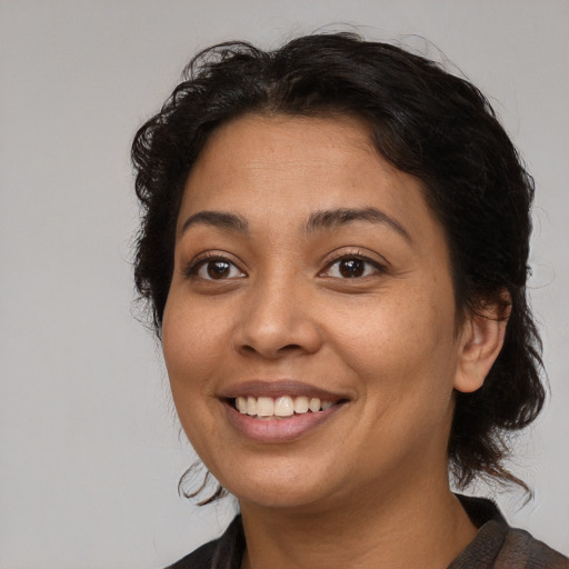 Joyful black young-adult female with medium  brown hair and brown eyes