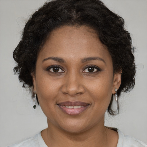 Joyful black young-adult female with long  brown hair and brown eyes